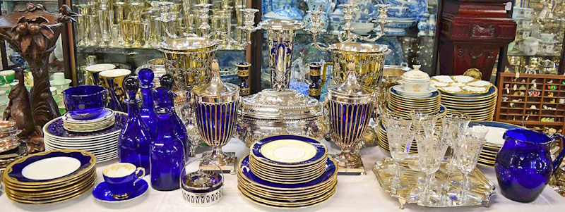 Estate sale jewelry display table featuring mixed vintage costume jewelry, sterling silver pieces, antique brooches, and potentially valuable designer finds arranged for treasure hunters to examine and authenticate - garage sale shopping guide InfoProds 2026