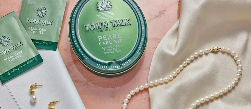 Pearl Jewelry Care - Special Handling and Cleaning for Delicate Organic Gems Delicate pearl necklace being gently wiped with soft cloth showing special care required for organic gemstones
