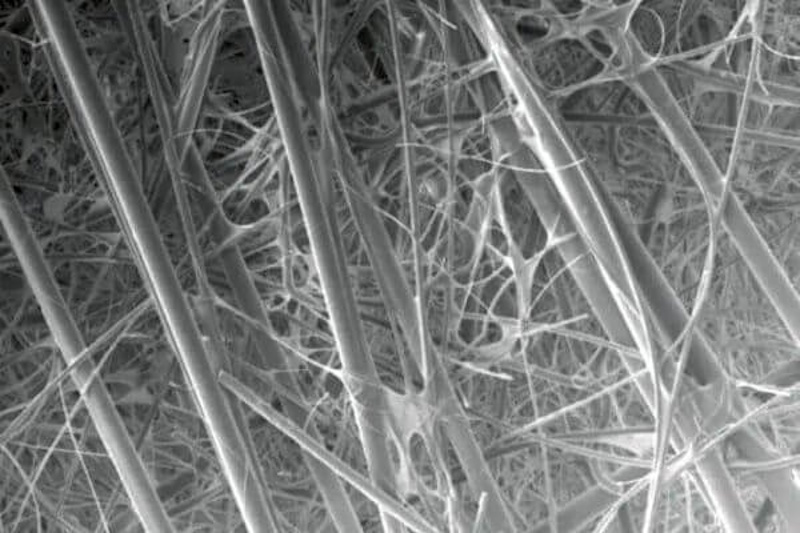 Microscopic cross-section view of true HEPA filter media showing dense fiber structure capturing submicron particles through mechanical filtration achieving medical-grade air purification standards - InfoProds 2026