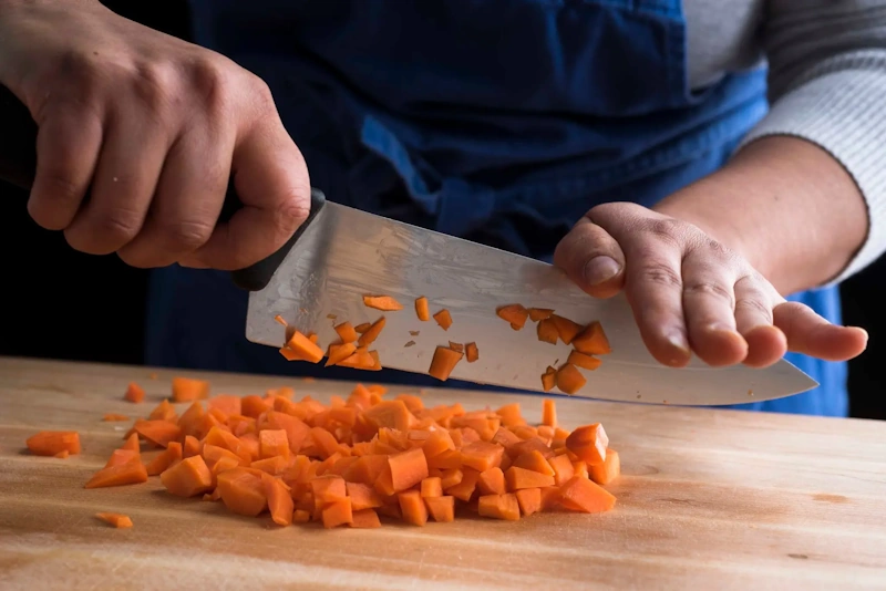 Professional chef demonstrating manual knife skills showing precision cutting technique versus electric food processor - manual kitchen tools InfoProds 2026