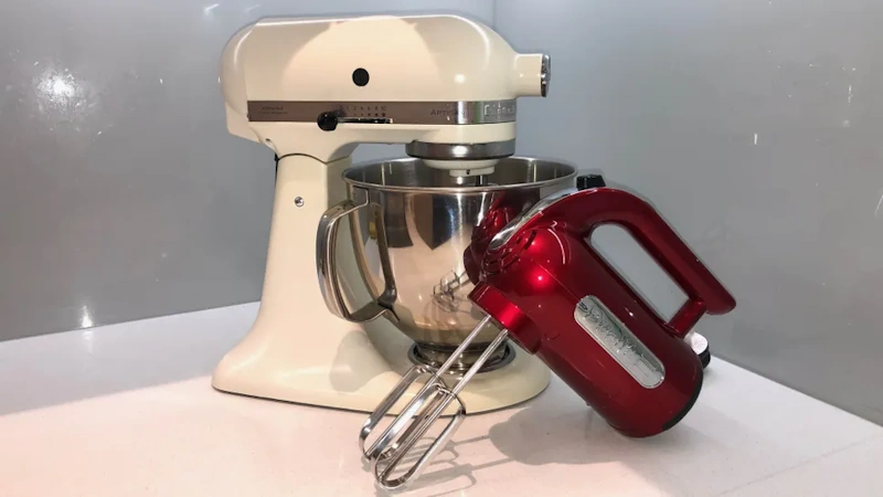 Manual balloon whisk beside electric stand mixer showing tool comparison for home cooking applications - mixing tools InfoProds 2026