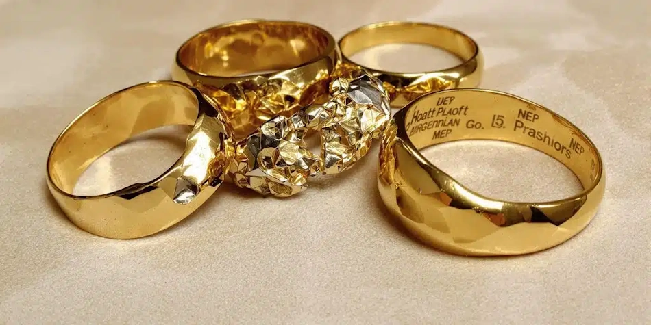 Heavy gold jewelry pieces showing deceptive weight perception Collection of heavy chunky gold bracelets and chains demonstrating how jewelry weight creates value perception despite varying gold purity levels InfoProds 2026