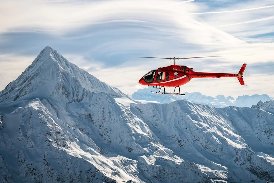 Rescue Helicopter Searching Snow Covered Landscape Using Thermal Imaging Technology Search and rescue helicopter flying over snow-covered terrain using thermal imaging and GPS technology to locate stranded vehicles during winter storm emergency response operations - InfoProds 2026