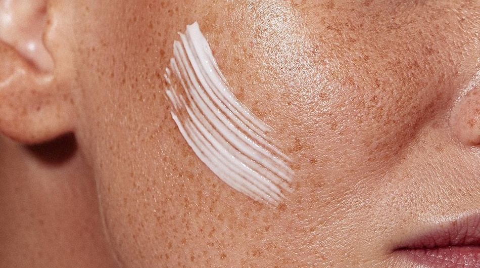 Woman applying moisturizer cream to damp facial skin immediately after cleansing proper skincare technique demonstration Young woman demonstrating proper moisturizer application technique by applying hydrating cream to damp facial skin immediately after gentle cleansing to lock in moisture and prevent transepidermal water loss - InfoProds 2026 skincare routine tutorial