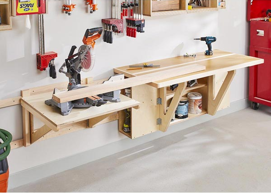 A high-quality L-shaped folding workbench fully deployed in a garage workshop setting, showing the sturdy hinges, locking mechanisms, and hardwood surface with organized tools nearby — InfoProds 2026
