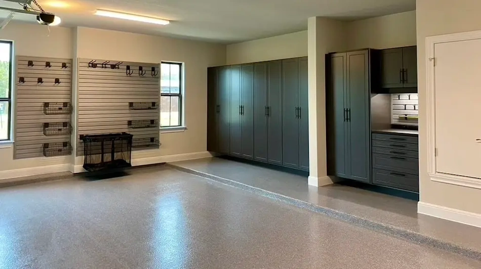 A well-insulated garage workshop with spray foam walls, an insulated garage door, anti-fatigue mats on the floor, and a portable heater — showing best practices for year-round garage workshop climate control as recommended by InfoProds 2026