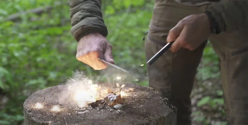 Person practicing fire-starting with ferro rod in backyard survival training Person practicing essential fire-starting survival skills using ferro rod and natural tinder in backyard training environment demonstrating practical weekend learning - InfoProds 2026