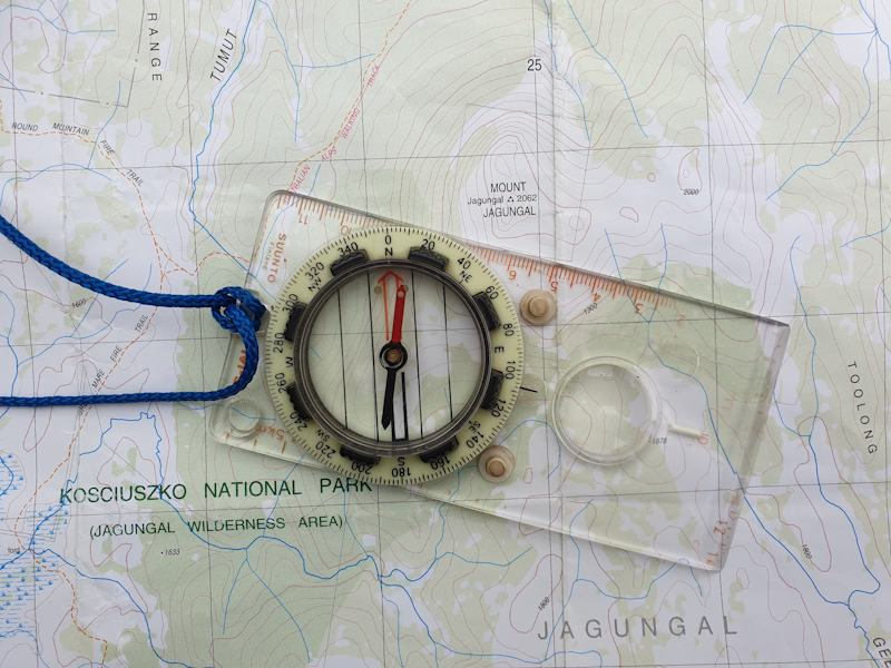 Navigation practice using topographic map and compass in outdoor setting Navigation training with topographic map and compass showing bearings route planning and terrain association skills essential for wilderness survival and emergency situations - InfoProds 2026