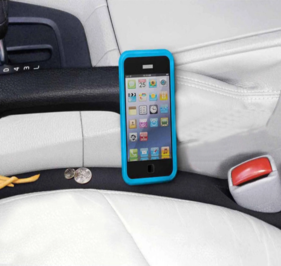 Phone Dropped Between Car Seats Rescue Solution 2026 Modern car seat gap filler preventing smartphone from disappearing between driver seat and center console, showing protective barrier blocking the notorious gap where phones, keys, and valuables typically vanish in vehicles, featuring premium leather material matching automotive interior - InfoProds 2026