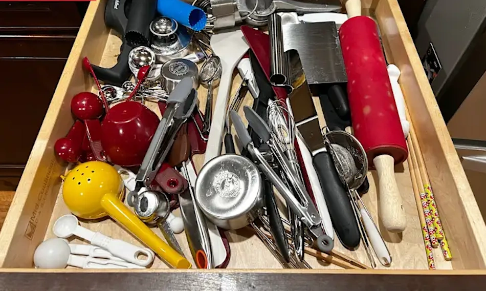 Multiple duplicate vegetable peelers measuring spoons and can openers scattered in cluttered kitchen drawer representing unnecessary purchases from poor organization - InfoProds 2026 duplicate tool analysis
