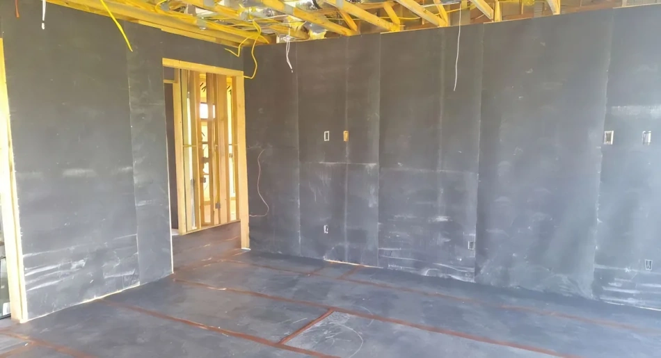 Mass Loaded Vinyl Sound Barrier Installation on Apartment Wall Professional installing heavy mass-loaded vinyl acoustic barrier material on apartment wall surface using temporary mounting system, showing flexible sound-blocking sheet that provides 12-18 decibel noise reduction while remaining completely removable for rental situations, demonstrating renter-friendly military-grade soundproofing techniques - InfoProds 2026