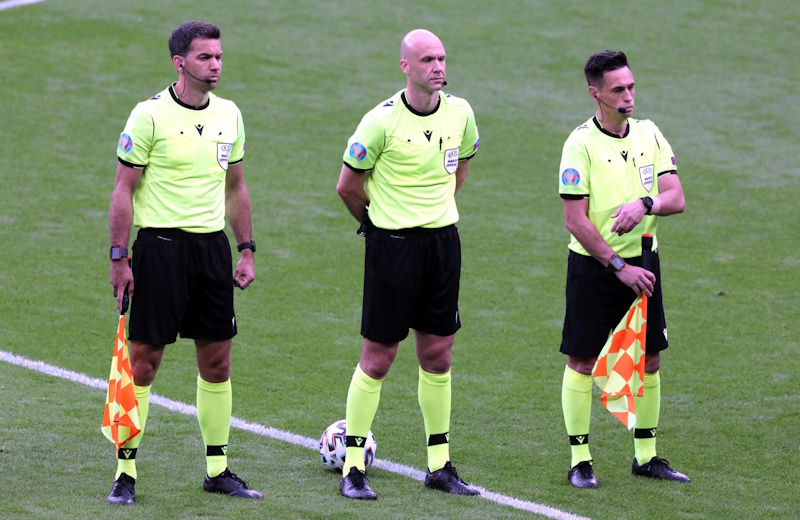 Soccer referee managing match temperature through selective foul calling and yellow card timing controlling escalation using psychological advantage that fans never see explicitly - InfoProds 2026