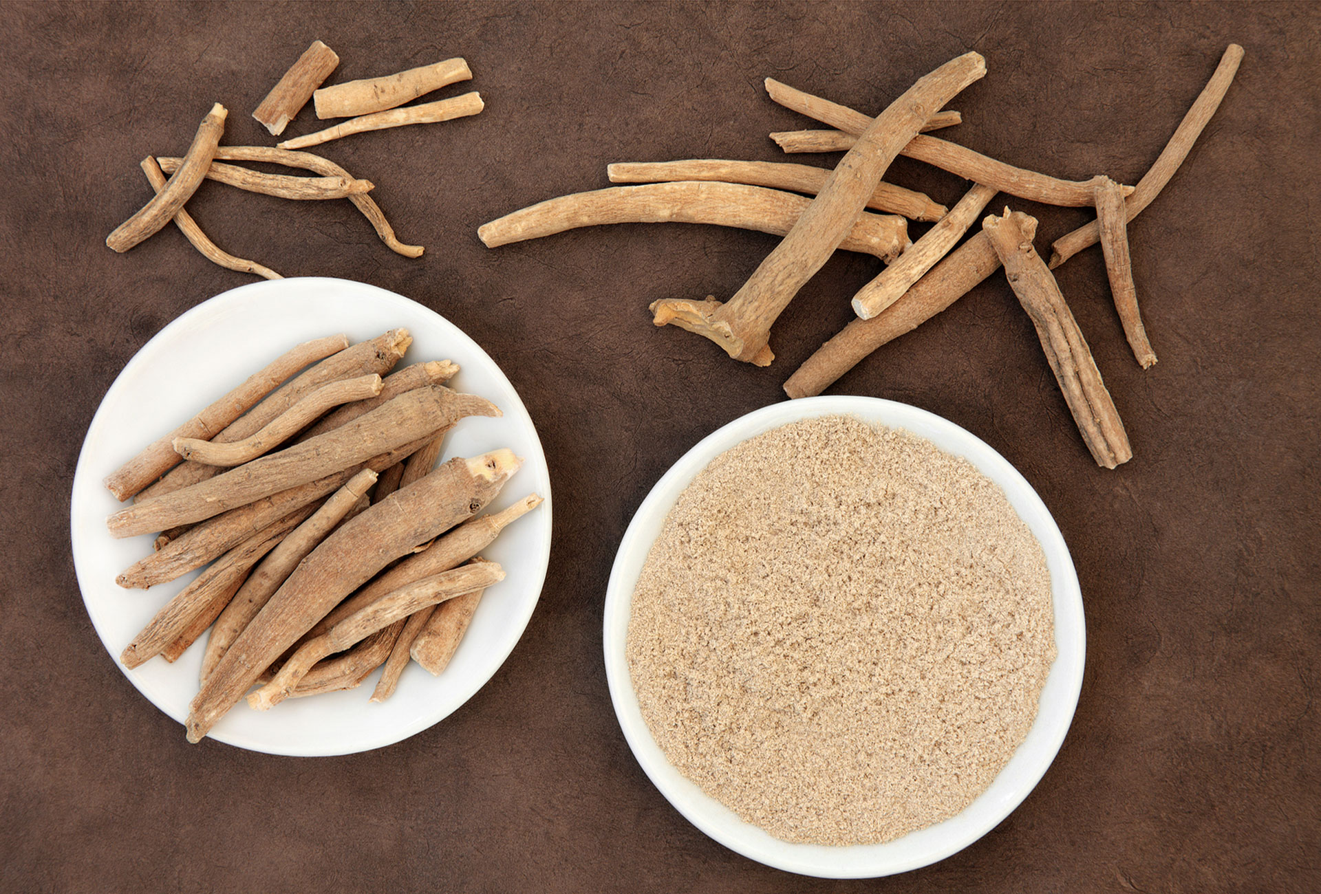 Dried ashwagandha roots and powdered extract arranged in a natural setting