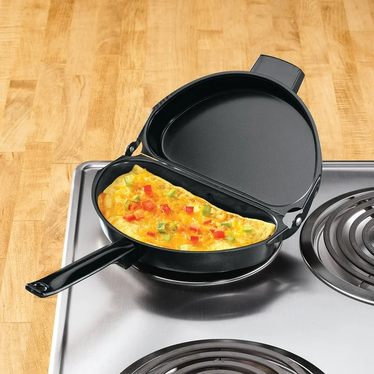 A close-up high-definition shot of a perfect yellow omelet sliding effortlessly in a black nonstick frying pan, showcasing modern kitchen convenience and smooth surface technology - InfoProds 2026